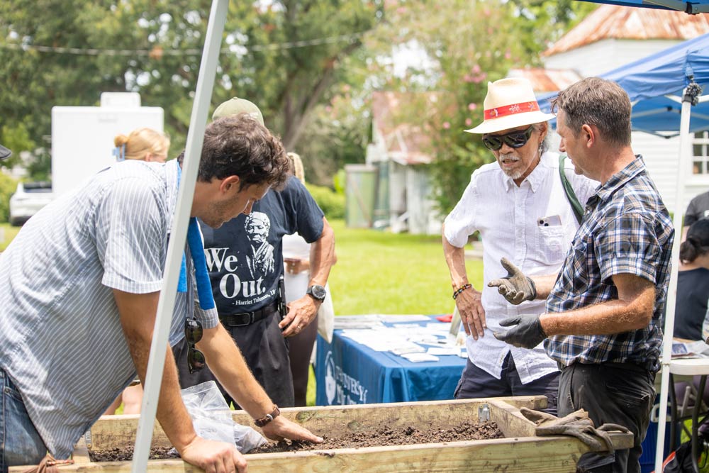 2. Woodland Advisory Board Member and UNO Archeology professor, Dr. Ryan Gray (on far right), showcasing found artifacts from campus archeological digs to community members during the 2025 Julyteenth program. Community Archeology days will be a part of Woodland’s forthcoming educational programming.