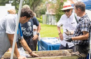 Woodland Advisory Board Member and UNO Archeology professor, Dr. Ryan Gray (on far right), showcasing found artifacts from campus archeological digs to community members during the 2025 Julyteenth program.