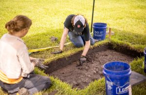 Woodland Advisory Board Member and UNO Archeology professor, Dr. Ryan Gray (on far right), showcasing found artifacts from campus archeological digs to community members during the 2025 Julyteenth program.